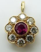 An 18ct gold pendant set with a round cut ruby of approximately 0.7ct surrounded by eight diamonds