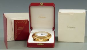 A Cartier desk alarm clock in original case and box. Brass case with folding stand, Roman dial,