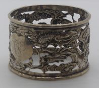 Chinese white metal embossed and pierced napkin ring with dragon decoration, with Chinese