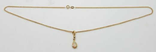 An 18ct gold pendant set with an opal and two diamonds on a 9ct gold chain