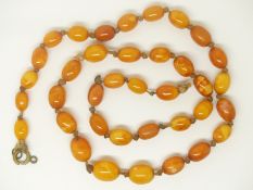 A Baltic amber necklace made up of graduated oval beads, largest bead 1cm x 0.8cm, 13g