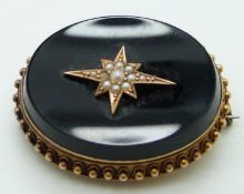 Victorian mourning brooch set with onyx, with seed pearls in a star setting to the centre and
