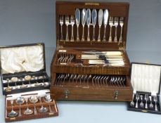 An oak cased six place setting canteen of cutlery together with three further boxed sets of cutlery