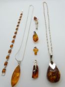 A collection of silver and pressed amber jewellery including bracelet, three pendants and brooch