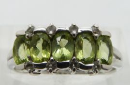 A 9ct white gold ring set with peridot and diamonds, size N