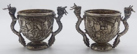 Pair of Chinese white metal open salts with embossed decoration of figures and buildings, the