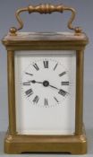 Early to mid twentieth century brass carriage clock in corniche style case, the white enamel dial