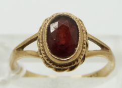 A 9ct gold ring set with a garnet, size K