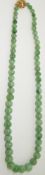 A jade necklace made up of spherical graduated beads, with  filigree clasp length 50cm