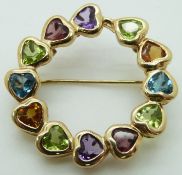 A 14ct gold brooch set with heart cut garnets, amethysts, peridot, topaz and citrine