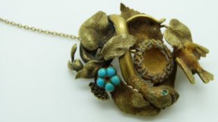 Victorian brooch in the form of a snake wrapped around a bird's nest amongst foliage, with
