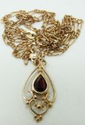 A 9ct gold pendant set with a garnet on a 9ct gold chain, 4.1g