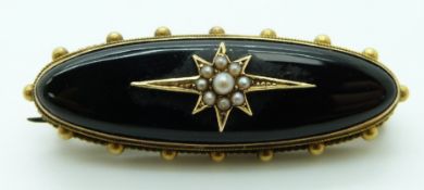 Victorian brooch set with onyx and seed pearls to the centre in a star setting