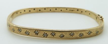 A 9ct gold bangle set with diamonds in star settings,17.1g