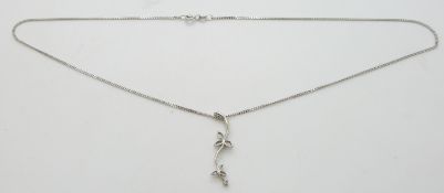 A platinum pendant set with a diamond in a floral design, 2.4g and a 9ct white gold chain, 2.5g