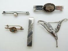A silver tie clip, Victorian knot brooch, silver crane brooch, a pearl brooch and a smoky quartz