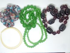 A cherry amber necklace and two Victorian glass necklaces