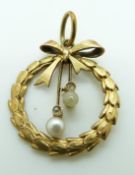 A 14ct gold pendant set with diamonds and a pearls in a wreath and bow design, 2cm