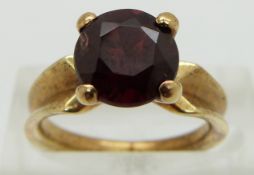 A 14ct gold ring set with a round cut garnet, size I