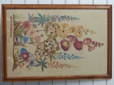 An embroidered silk tapestry of lupins and hollyhocks, dated October 1952 signed DNB