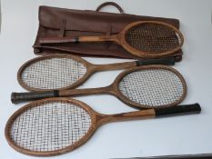Four vintage tennis rackets and a leather carry case.