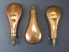 Three copper and brass powder flasks one A M Flask & Cap Co (21cm long) and two others.