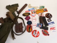 A collection of gun parts and accessories including magazines, bullets, webbing, oil bottles, badges