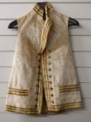 A 19thC velvet waistcoat with dyed coloured trim, a double row of service buttons and two trimmed