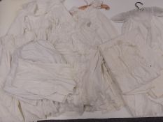 A quantity of 19th / 20thC textiles including children's hand embroidered petticoats, aprons,