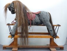 Vintage rocking horse with grey fur, brown mane and tail, glass eyes, leather saddle and wooden