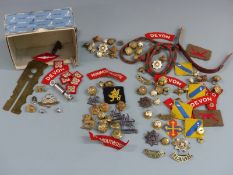 A collection of military badges, buttons etc for the Devonshire Regiment and Monmouthshire
