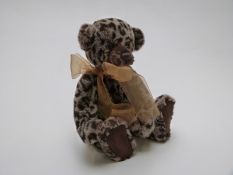 Charlie Bears Teddy bear with leopard print mohair, jointed limbs, scarf and bells, 33cm tall.