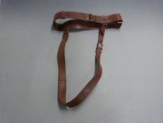 Brown leather Sam Brown belt with brass mounts.