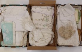 A large collection of linen and lace including several tablecloths, some unused