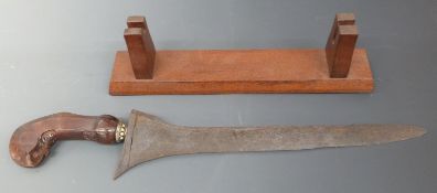 A 19thC Malayan Kris with carved handle and jewelled mount, on later stand, 42cm
