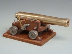 Signalling or display model cannon with 33cm graduated brass barrel raised on oak carriage and