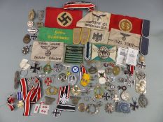 A quantity of reproduction Nazi German WWII badges and regalia including armbands