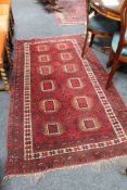 A fringed Afghan Tekke woollen rug on red ground,
