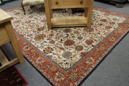 An Indian carpet, with an allover design of vines on a cream central field,