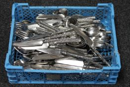 A basket containing a set of stainless steel cutlery