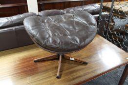 A mid 20th century brown leather revolving footstool on rosewood base