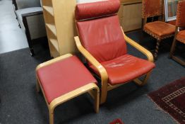 A contemporary beech framed red leather armchair with stool
