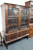 A mid twentieth century mahogany double door display cabinet fitted with four drawers beneath