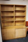 A late 20th century set of teak shelves with cupboard below