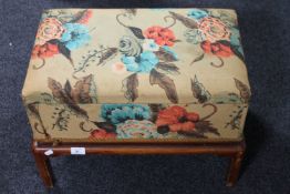 A twentieth century upholstered storage foot stool on pine legs