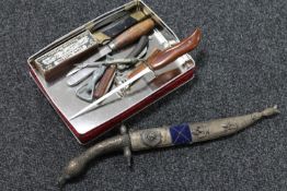 A tin of pen knives, cigar cutter, bottle opener, letter opener,