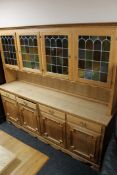A 20th century blonde oak four door dresser with coloured stained glass panels