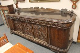 An impressive continental carved mahogany sideboard on oversized paw feet CONDITION