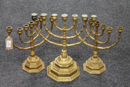 Three heavy brass menorahs on octagonal bases
