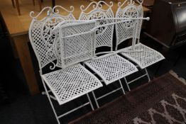 A set of four folding metal garden chairs
